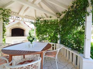una mesa y sillas en una pérgola con plantas en Apartment Villa MatAna-1 by Interhome en Trogir