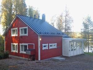 ein rotes Haus mit Garage im Hof in der Unterkunft Holiday Home Siimaranta by Interhome in Vehmersalmi