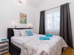 Un dormitorio con una cama grande con almohadas azules. en Apartment Villa MatAna-1 by Interhome en Trogir
