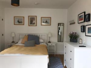a bedroom with a white bed and a white dresser at The Retreat in Sheringham