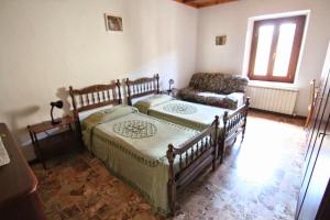 a bedroom with a bed and a couch at Santa Caterina Bed and Breakfast in Badesse