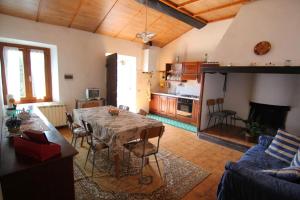 a living room with a table and a kitchen at Santa Caterina Bed and Breakfast in Badesse