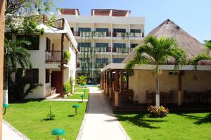 un edificio con un patio de césped frente a un edificio en Hotel Posada Sian Kaan Playa del Carmen en Playa del Carmen