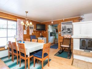 ein Esszimmer mit Tisch und Stühlen und einem Kamin in der Unterkunft Holiday Home Mäntyrinne by Interhome in Haapaniemi + 21 Fotos