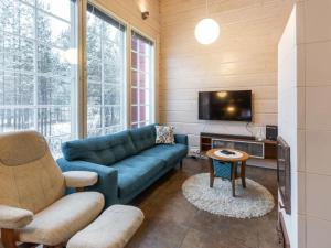 a living room with a blue couch and a tv at Holiday Home Kätkänlinna a1 by Interhome in Levi