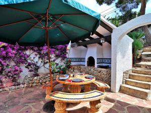 a table with an umbrella on a patio at Holiday Home Flova by Interhome in Balcon del Mar