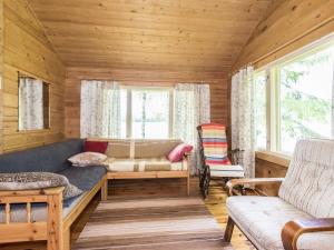 a living room with a couch and a chair at Holiday Home Kuoppamäki by Interhome in Lapinlahti