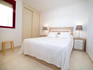 a white bedroom with a white bed and a window at Apartment Amatista-7 by Interhome in Calpe