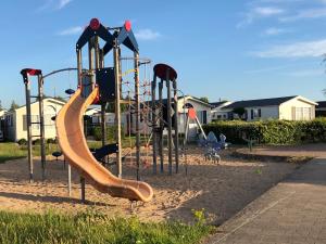 a playground with a slide in the sand at Haerendycke Park in De Haan