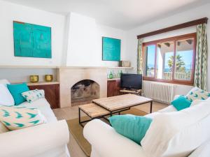 sala de estar con 2 sofás blancos y chimenea en Villa Son Granada by Interhome, en Cala Blava
