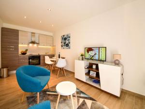 a living room with a blue chair and a table at Holiday Home Matea by Interhome in Rijeka