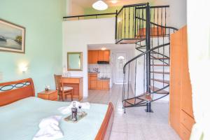 a room with a bed and a spiral staircase at House Ilias in Sarti