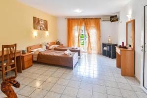 a room with two beds and a desk and a kitchen at House Ilias in Sarti