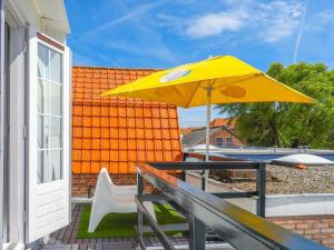 a yellow umbrella sitting on a table on a deck at Holiday Home Brouwershaven by Interhome in Brouwershaven