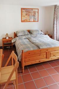 a bedroom with a large bed and a chair at Holiday Home Den Osse by Interhome in Brouwershaven