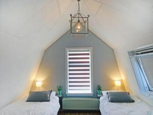 a attic bedroom with two beds and a window at Holiday Home Brouwershaven by Interhome in Brouwershaven