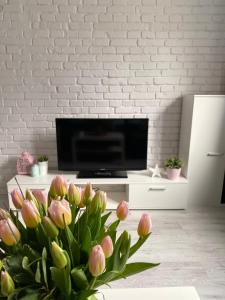 a living room with a television and a vase of flowers at Apartamenty ToTuGdynia 5 in Gdynia