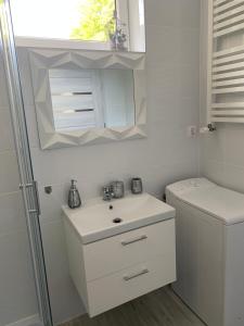 a white bathroom with a sink and a toilet at Apartamenty ToTuGdynia 5 in Gdynia