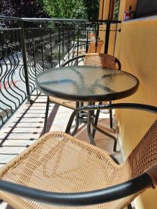 a glass table and chairs on a balcony at CASA GABI'S in Orşova
