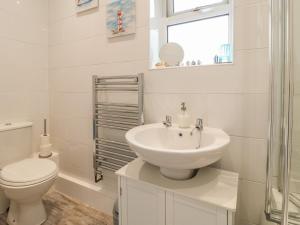 bagno bianco con servizi igienici e lavandino di Church View Cottage a Rugeley