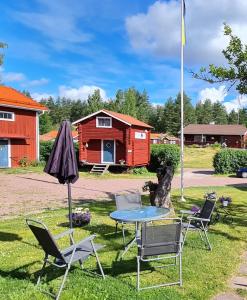 una mesa y sillas frente a una cabaña en B&B Parkgården Leksand en Leksand