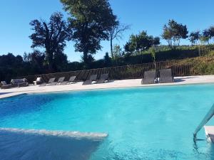 a swimming pool with lounge chairs and a swimming pool at Le Mas du Lingousto in Cuers