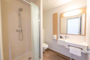 a bathroom with a shower and a toilet and a sink at B&B HOTEL PERPIGNAN Nord Aéroport in Perpignan +68 photos