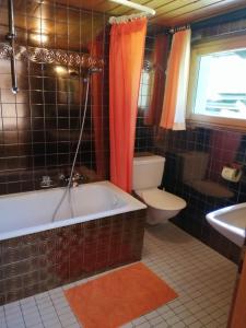 een badkamer met een bad, een toilet en een wastafel bij Ferienwohnung Waldhaus in Sankt Gallenkirch