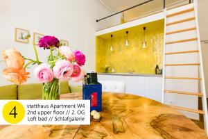 a vase of flowers on a table in a kitchen at statthaus - statt hotel in Cologne