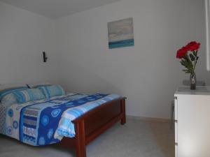a bedroom with a bed and a vase with a flower at Appartement Vallée de Luchon in Salles-et-Pratviel