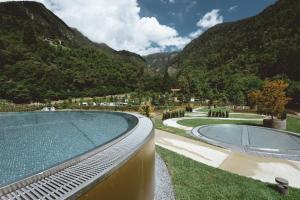 Ein Swimmingpool mit Bergen im Hintergrund in der Unterkunft Prinz Rudolf Smart Hotel in Meran