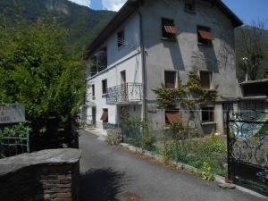 a white building with a balcony on a street at Appartement Vallée de Luchon in Salles-et-Pratviel