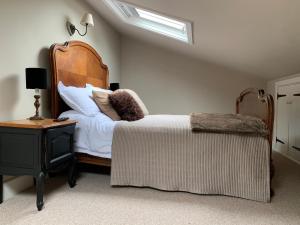 a bedroom with a bed with a wooden headboard and a table at Little Doric in Shepton Mallet