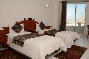 En eller flere senge i et værelse på Hotel Bouregreg