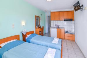 two beds in a small room with a kitchen at House Ilias in Sarti +5 photos