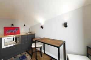 a small kitchen with a table and a microwave at Newly Refurbished Flat With Patio. By Hyde Park in London