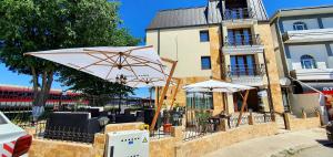 a patio with umbrellas in front of a building at Summer Love in Mangalia