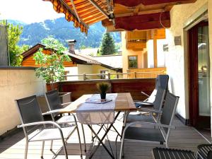 een houten tafel en stoelen op een patio bij BELLE KITZ im Zentrum by Belle Stay in Kitzbühel