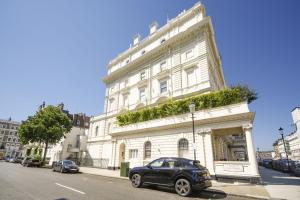 a black car parked in front of a white building at Newly Refurbished Flat With Patio. By Hyde Park in London