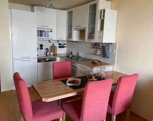 uma cozinha com uma mesa de madeira e cadeiras cor-de-rosa em Werz Sea View Apartment em Brela
