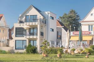 ein großes weißes Gebäude mit einem Rasen davor in der Unterkunft Ferienwohnung Arguna in Langenargen