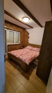 Bett in einem Zimmer mit Ziegelwand in der Unterkunft Matanovi Dvori in Slavonski Brod