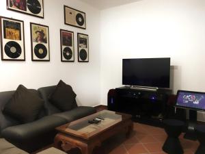 a living room with a couch and a flat screen tv at Heeren Straits Hotel in Malacca