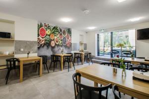 a restaurant with tables and chairs and a painting on the wall at Bema Rooms in Łódź