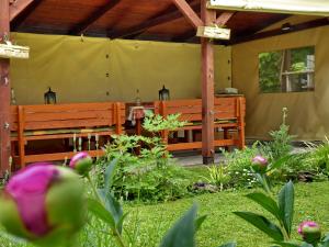 eine Terrasse mit zwei Holzbänken in einem Garten in der Unterkunft Illés Vendégház in Keszthely