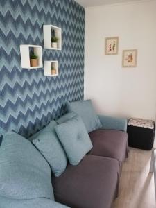 ein Wohnzimmer mit einem Sofa und blauen Kissen in der Unterkunft La Houle, maison classée 4 étoiles in Criel-sur-Mer