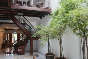 a staircase in a building with two potted trees at Heeren Straits Hotel in Malacca