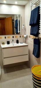 a bathroom with a sink and a mirror and blue towels at Cantinho do Auka - Studio in Aveiro +41 photos