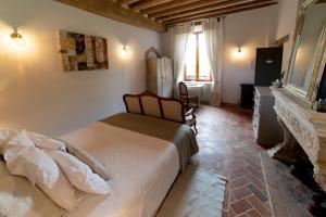 Schlafzimmer mit einem Bett, einem Schreibtisch und einem Kamin in der Unterkunft La Ferme de Bouchemont in Saint-Symphorien