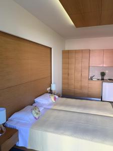 two twin beds in a bedroom with wooden walls at Georges Estates Hotel in Stoupa
